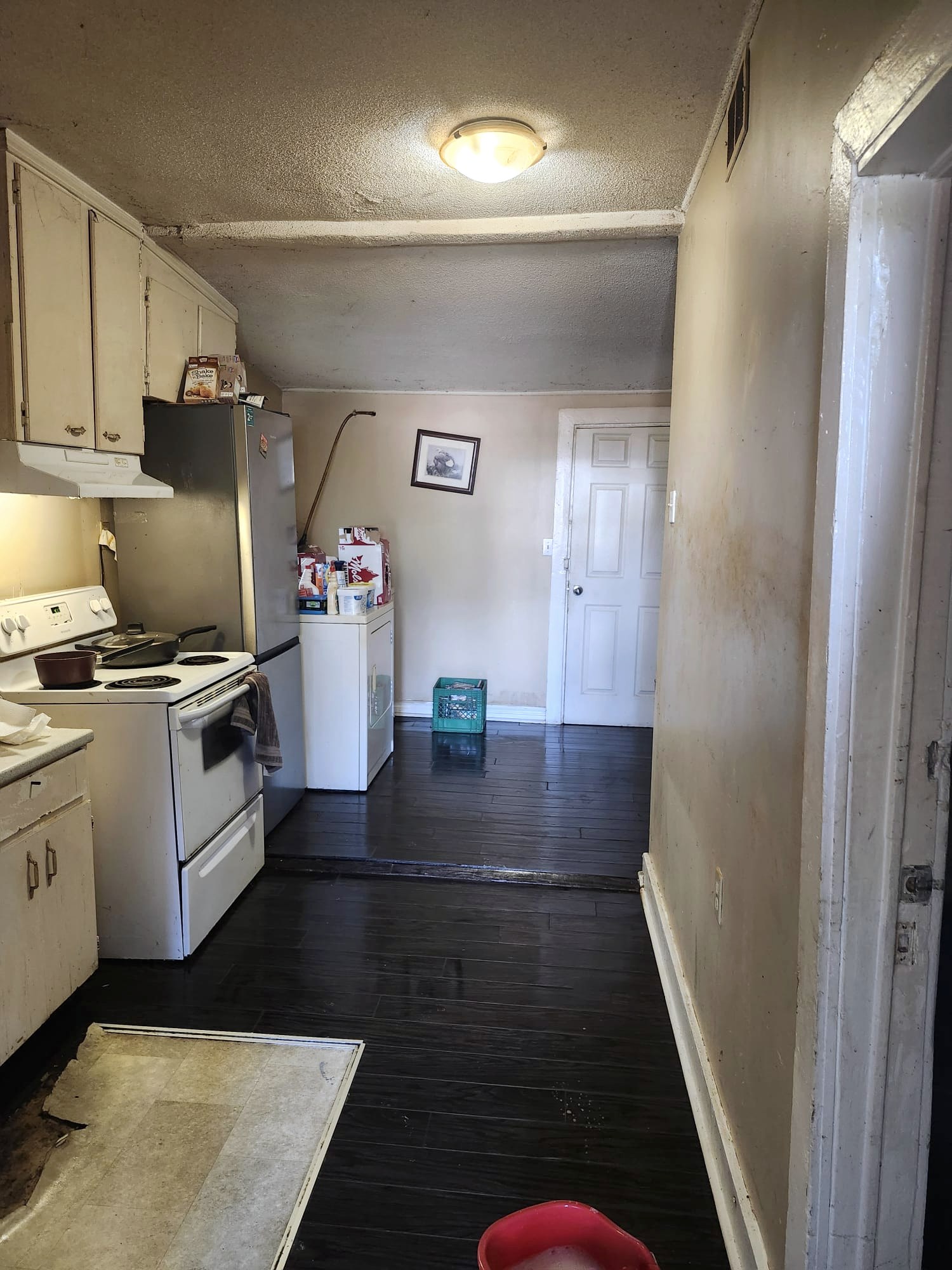 Kitchen with worn cabinets and floors before deep cleaning