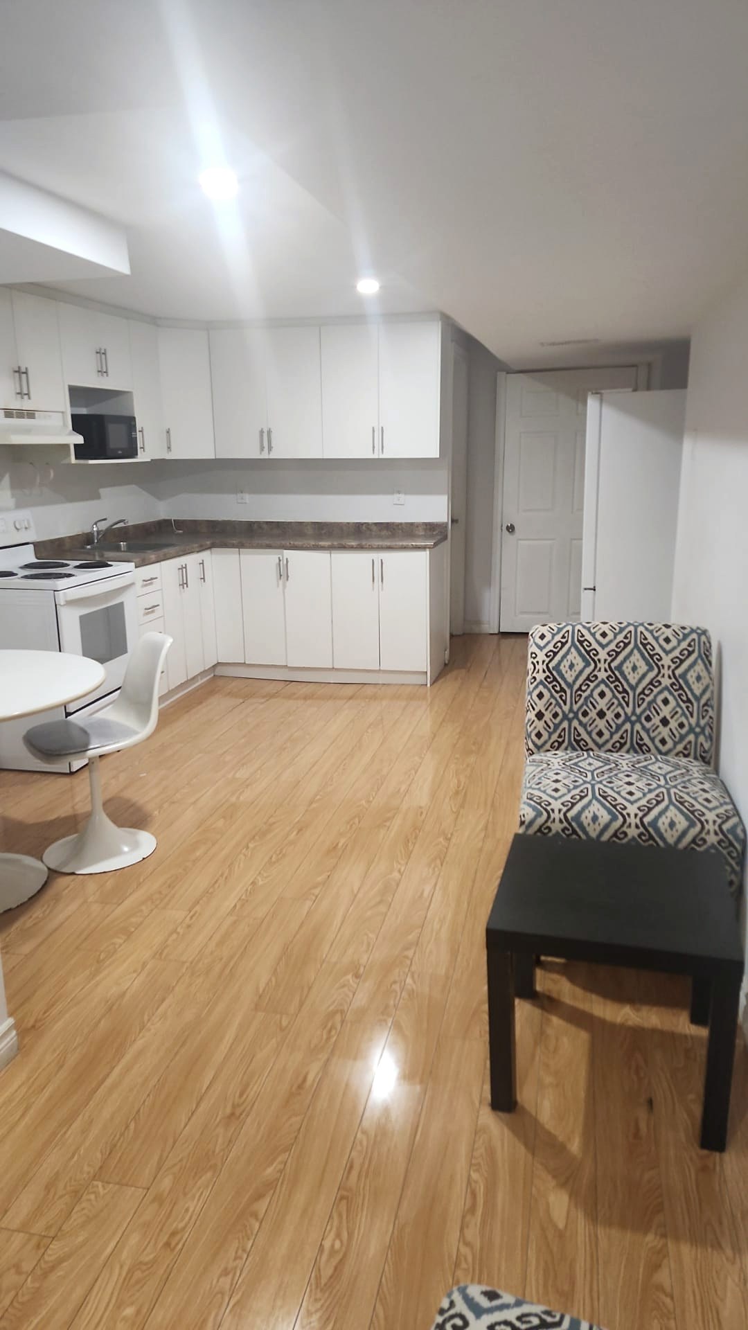 Bright basement suite with clean hardwood floors and kitchen