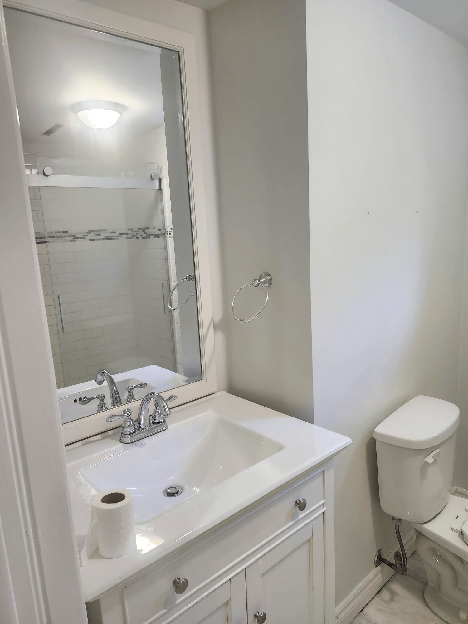 Sparkling white bathroom vanity, mirror and glass shower after a Lumina cleaning